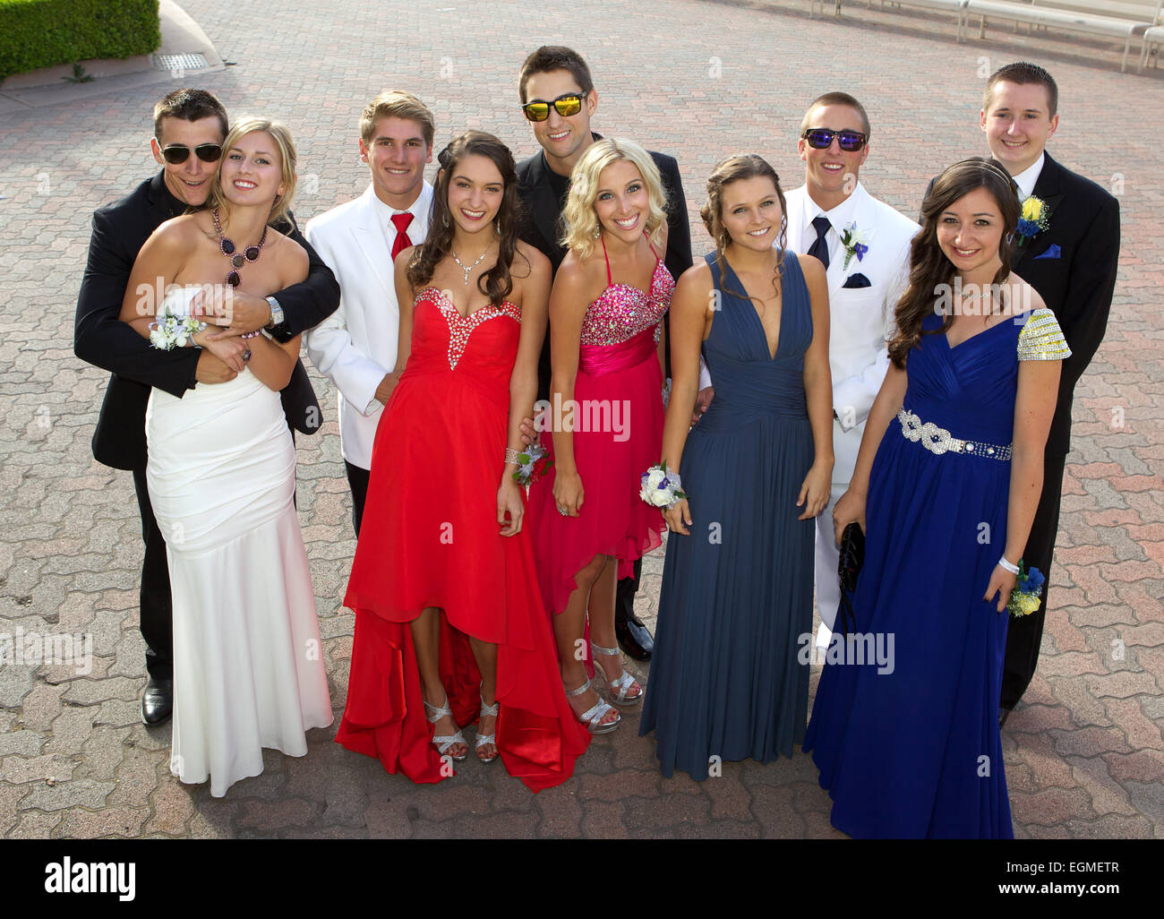 A happy group of high school students posing for a prom photo in their prom dresses and tuxedos Stock Photo