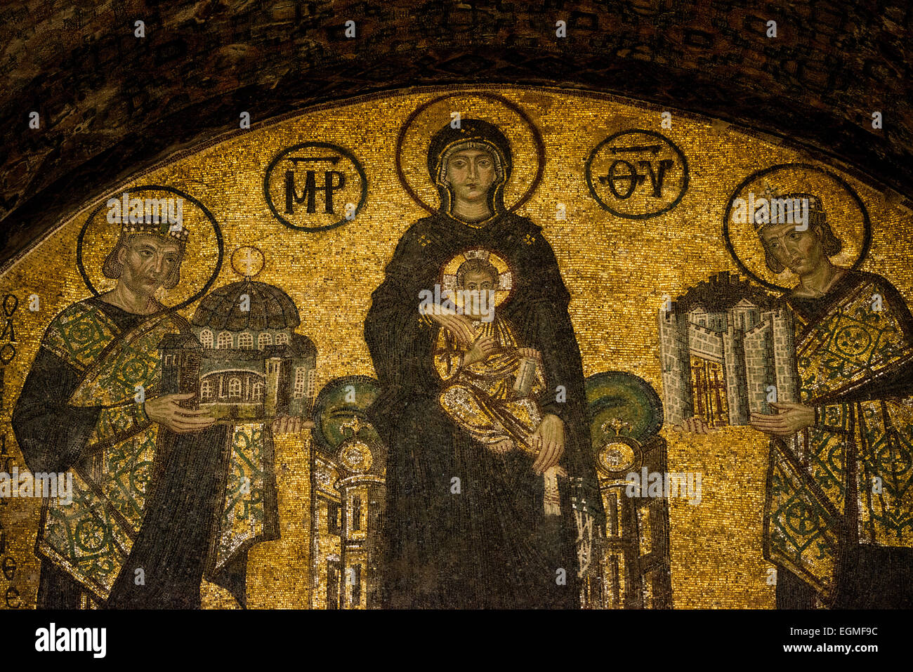 ISTANBUL, Turkey / Türkiye — A mosaic depicting the Virgin Mary and child flanked by Justinian I and Constantine I in Hagia Sophia. Dating to the 10th century. On the right is Emperor Constantine holding a model of the city of Constantinople. On the left is Emperor Justinian holding a model of Hagia Sophia. Originally built in 537, it has served as an Eastern Orthodox cathedral, a Roman Catholic cathedral, a mosque, and now a museum. Also known as Ayasofya or Aya Sofia, it is one of Istanbul's primary landmarks. Stock Photo