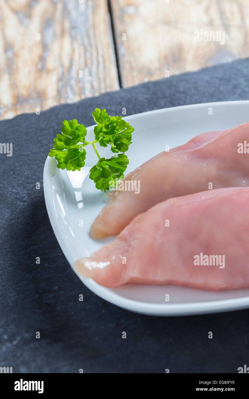 Two pieces of chicken breast fillet on a slate plate Stock Photo
