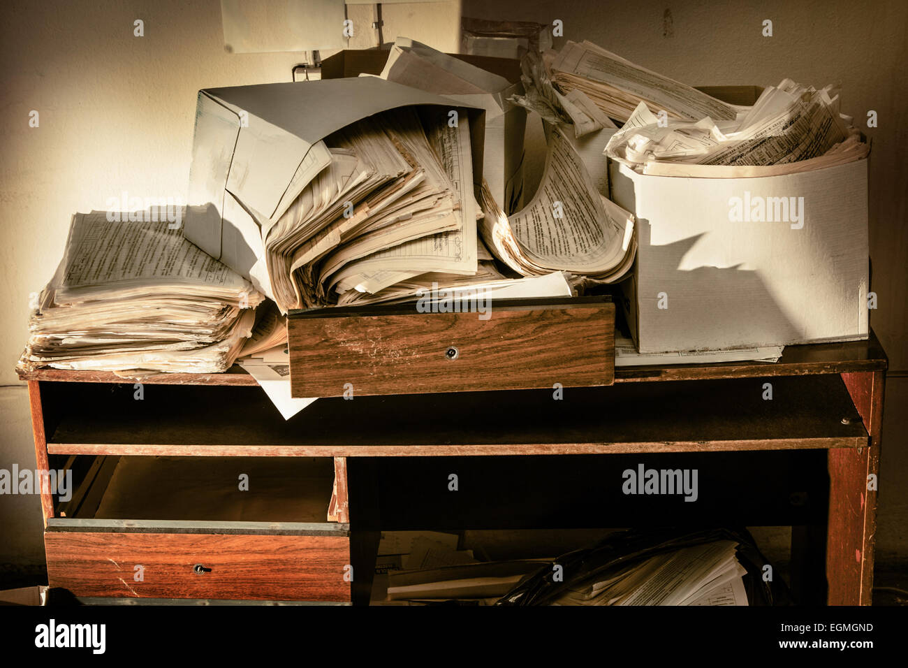 Messy workplace with table and stack of paper Stock Photo - Alamy