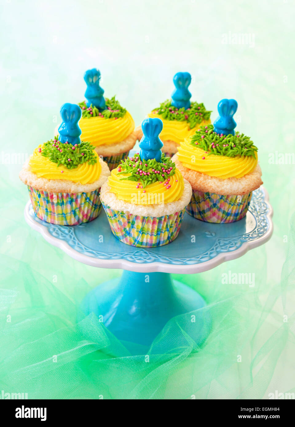 Easter cupcakes. Angel food cupcakes with yellow vanilla frosting and blue candy bunnies. Stock Photo