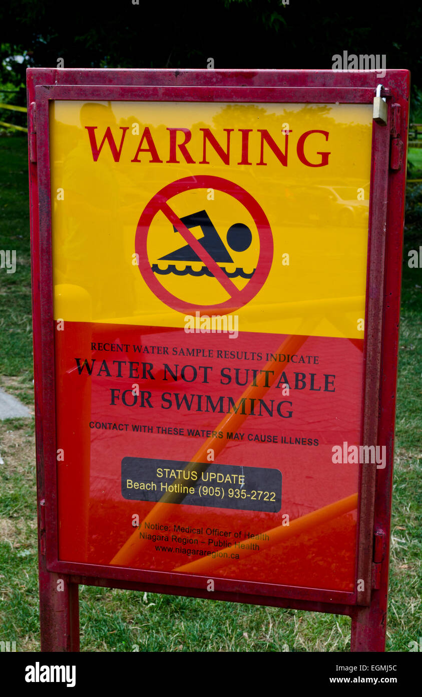 Public health warning sign cautioning that the water of Lake Ontario at Lakeside Park in St. Catharines is not safe for swimming due to contamination. Stock Photo