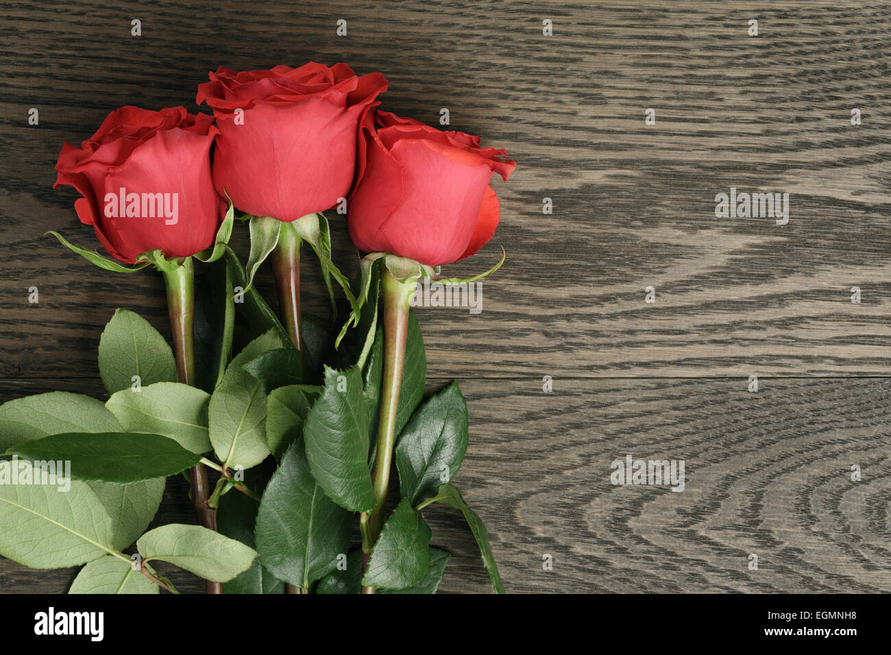 Romantic background with red roses on wood table Stock Photo - Alamy