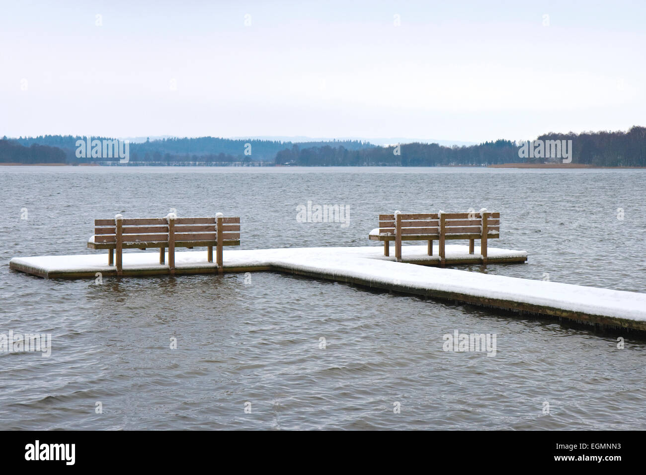 Empty benches on a bathing jetty at winter time Stock Photo