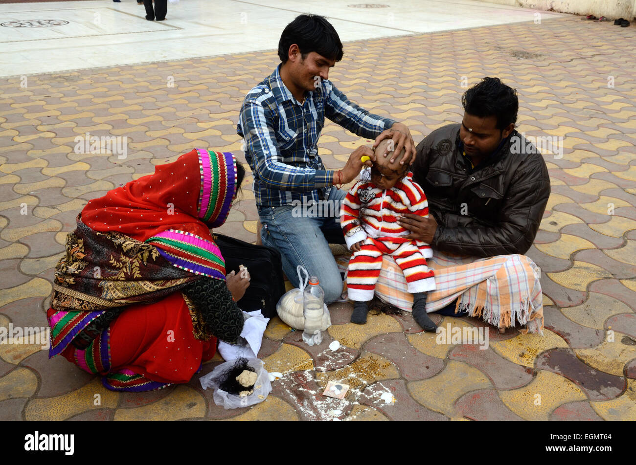Indian baby girl having her head  shaved in a Mundan Ceremony Ram Raja Temple Orchha Madhya Pradesh India Stock Photo