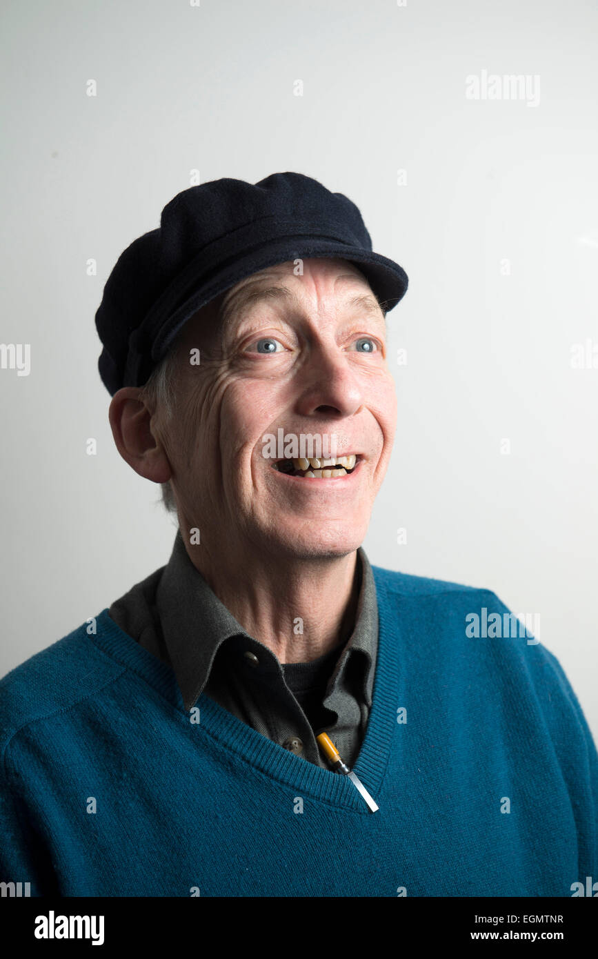 characterful funny old wise elder man in a peaked hat, v neck pullover sweater jumper, with pens looking like a mad professor Stock Photo