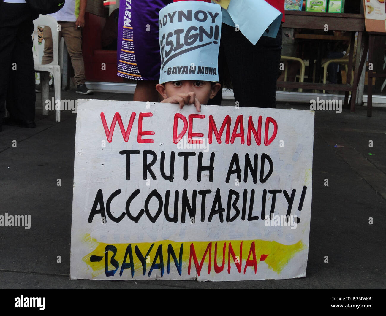 Manila, Philippines. 27th February, 2015. A child wearing a placard calling for the resignation of President Benigno Aquino III takes a rest during a rally at Mendiola Bridge near Malacanang Palace. The protesters are calling for the resignation of President Aquino over the Mamasapano incident that resulted in the deaths of wanted Malaysian bombmaker Zulkifri 'Marwan' bin Hir, 44 police commandos, 18 Muslim rebels, and 8 civilians. Credit:  Richard James Mendoza/Pacific Press/Alamy Live News Stock Photo