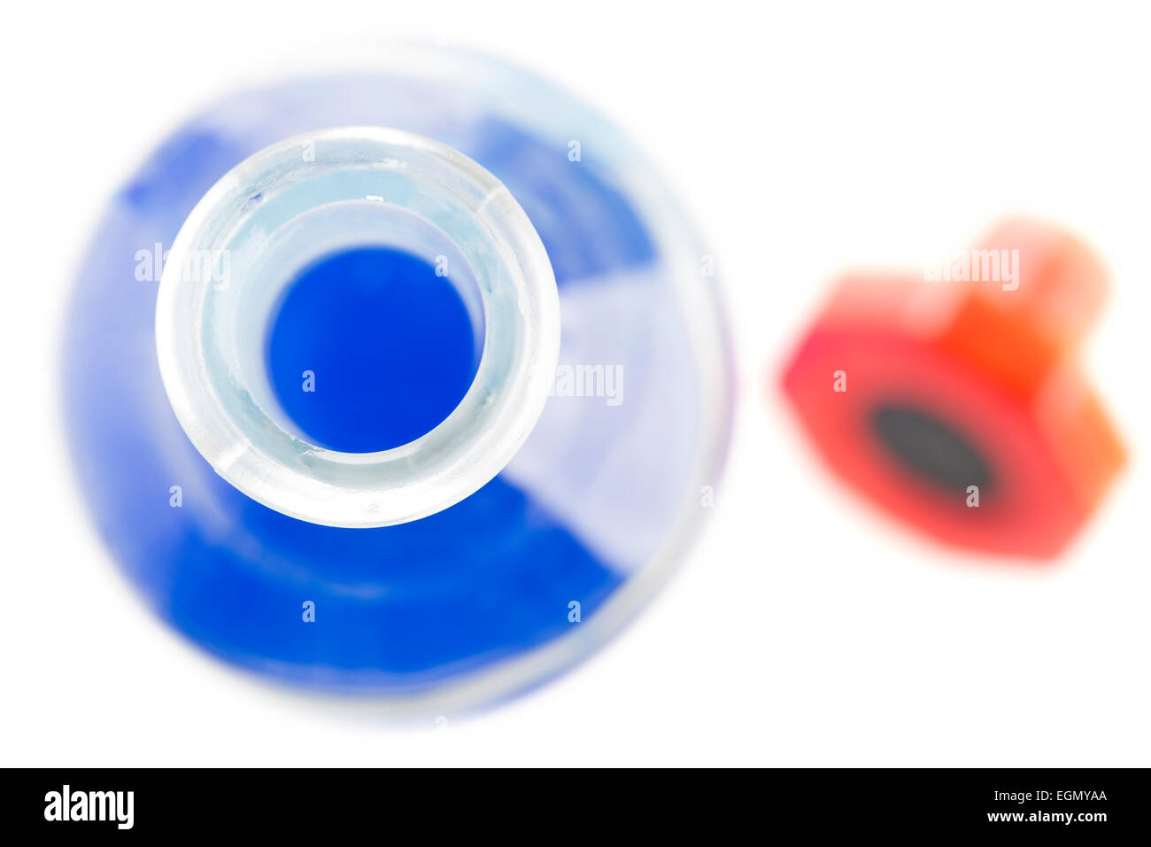 Bottle with blue Liquid from above, with red stopper out of focus. Stock Photo