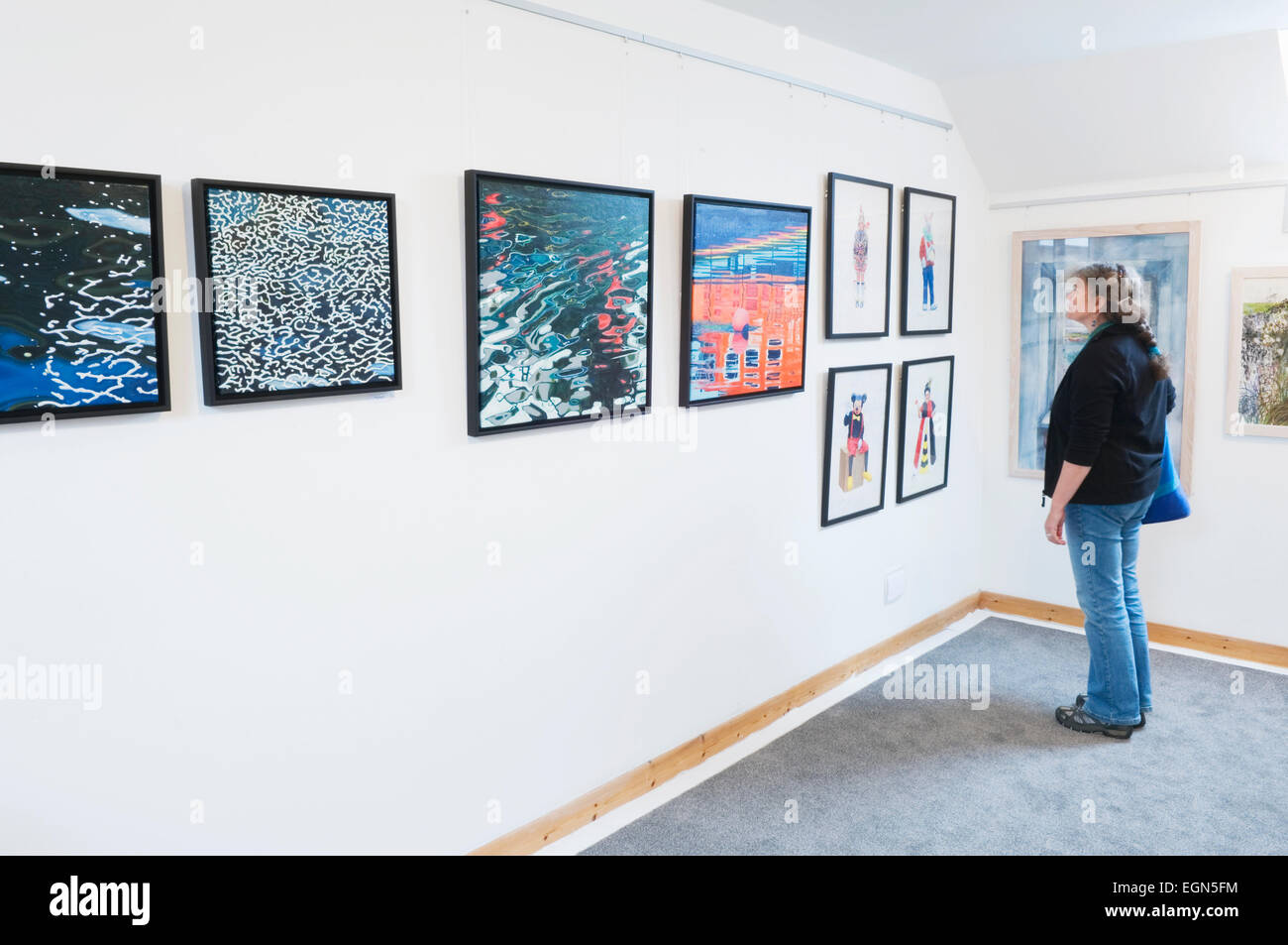 Woman looking at an exhibition in the Loft Gallery, St Margaret's Hope, South Ronaldsay, Orkney Islands, Scotland. Stock Photo