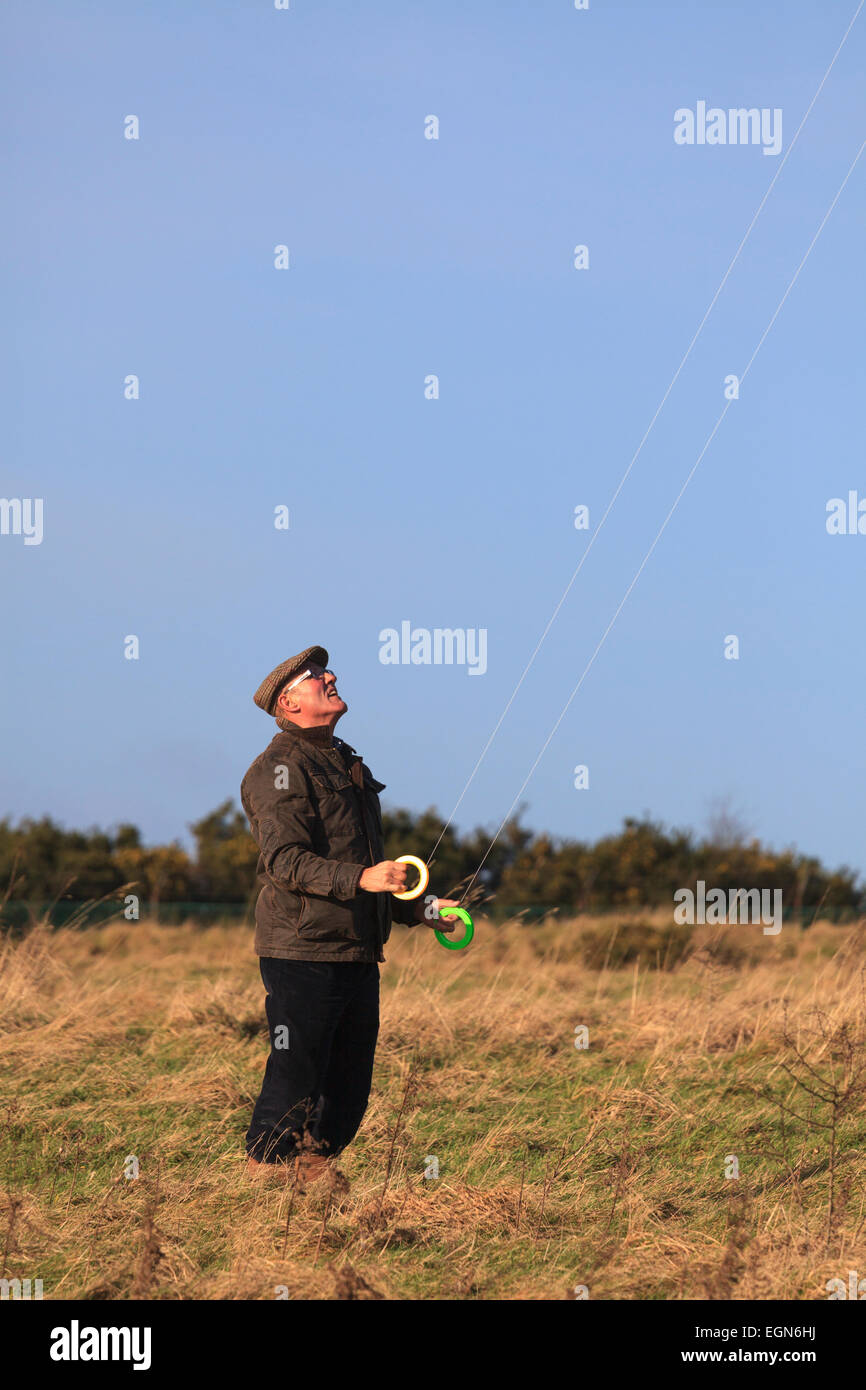 Older man flying stunt kite using dual control lines Stock Photo