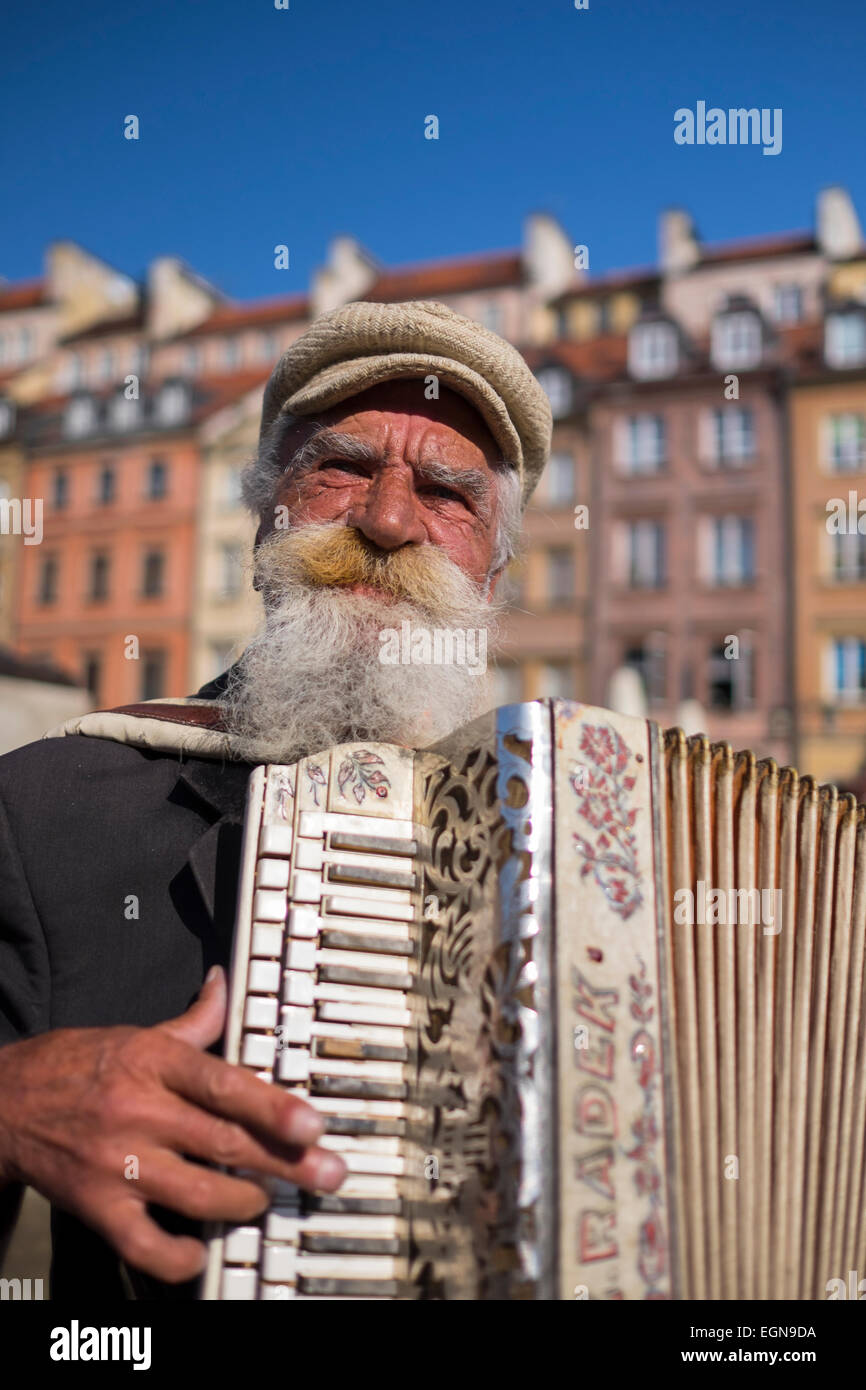Elderly man busking in Warsaw's Old Town, Poland Stock Photo