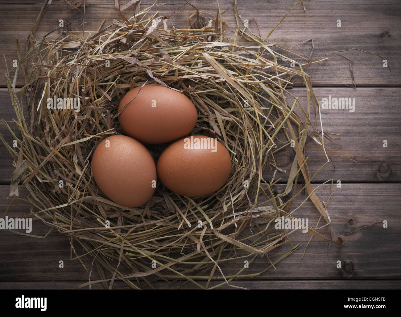 Eggs in hay nest on old wooden table background, top view Stock Photo ...