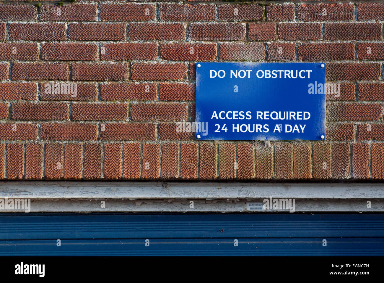 Do Not Obstruct sign above a blue garage door Stock Photo