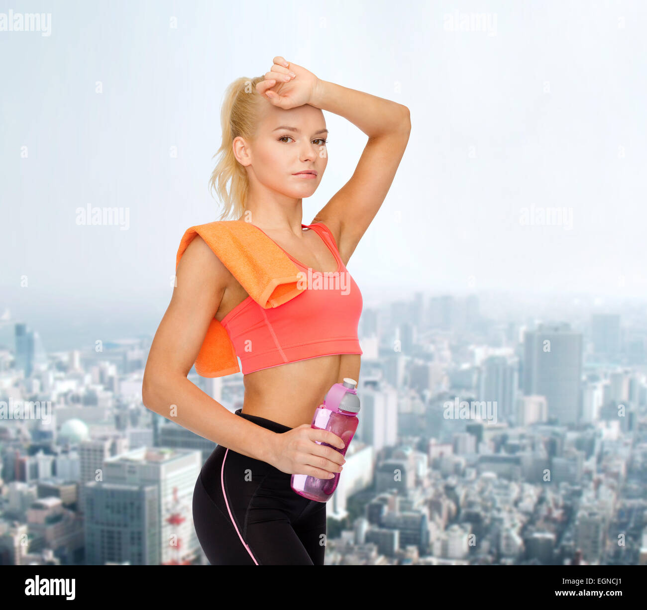 tired sporty woman with towel and water bottle Stock Photo - Alamy
