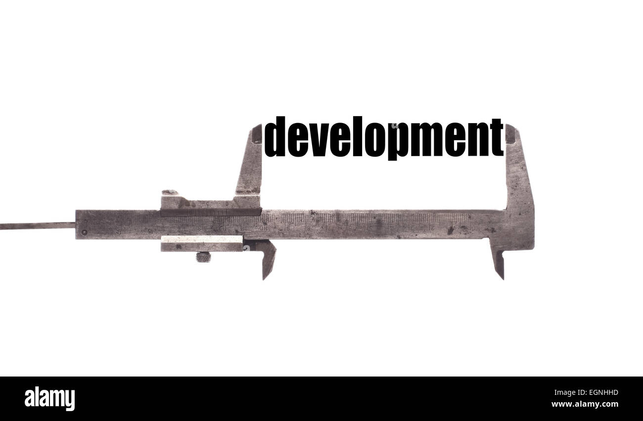 Color horizontal shot of a caliper measuring the word 'development'. Stock Photo
