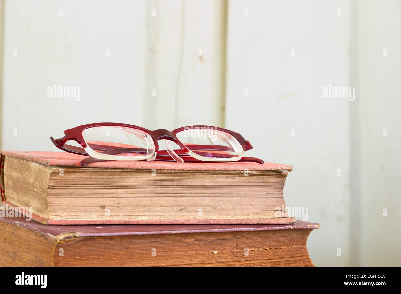 Closeup stack of old book pages texture with eye glasses. Stock Photo