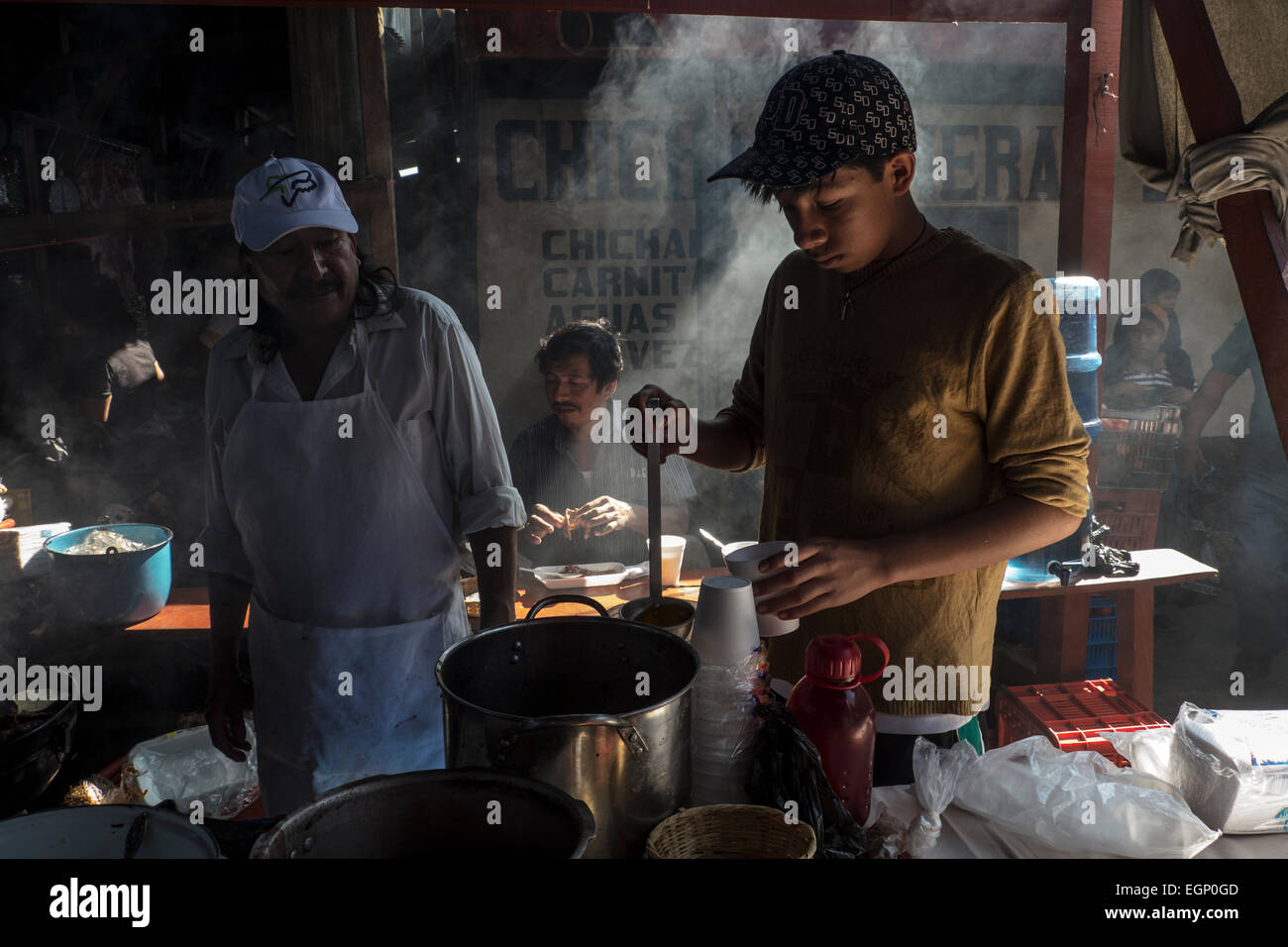 Boy pours a hot drink in an indigenous restaurant in Chichicastenango market in Guatemala Stock Photo