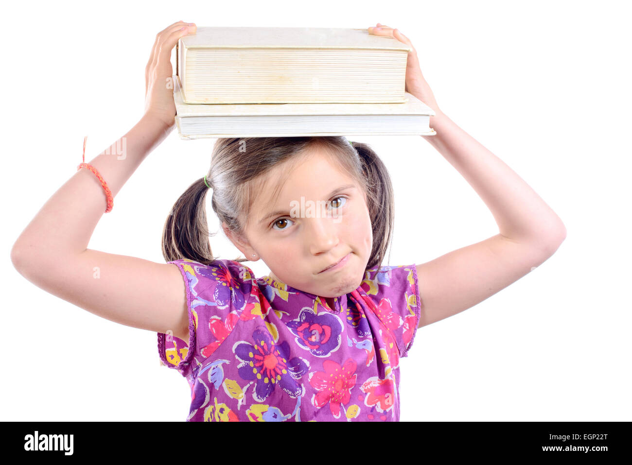 Schoolgirl with pile of books on head on white background Stock Photo ...