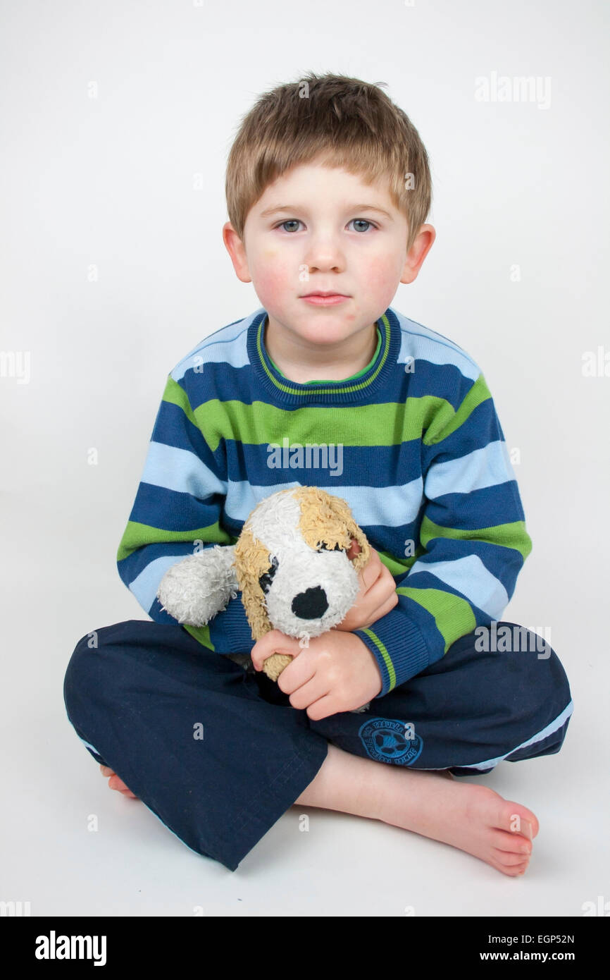 5 year old boy sitting with teddy bear puppy Stock Photo