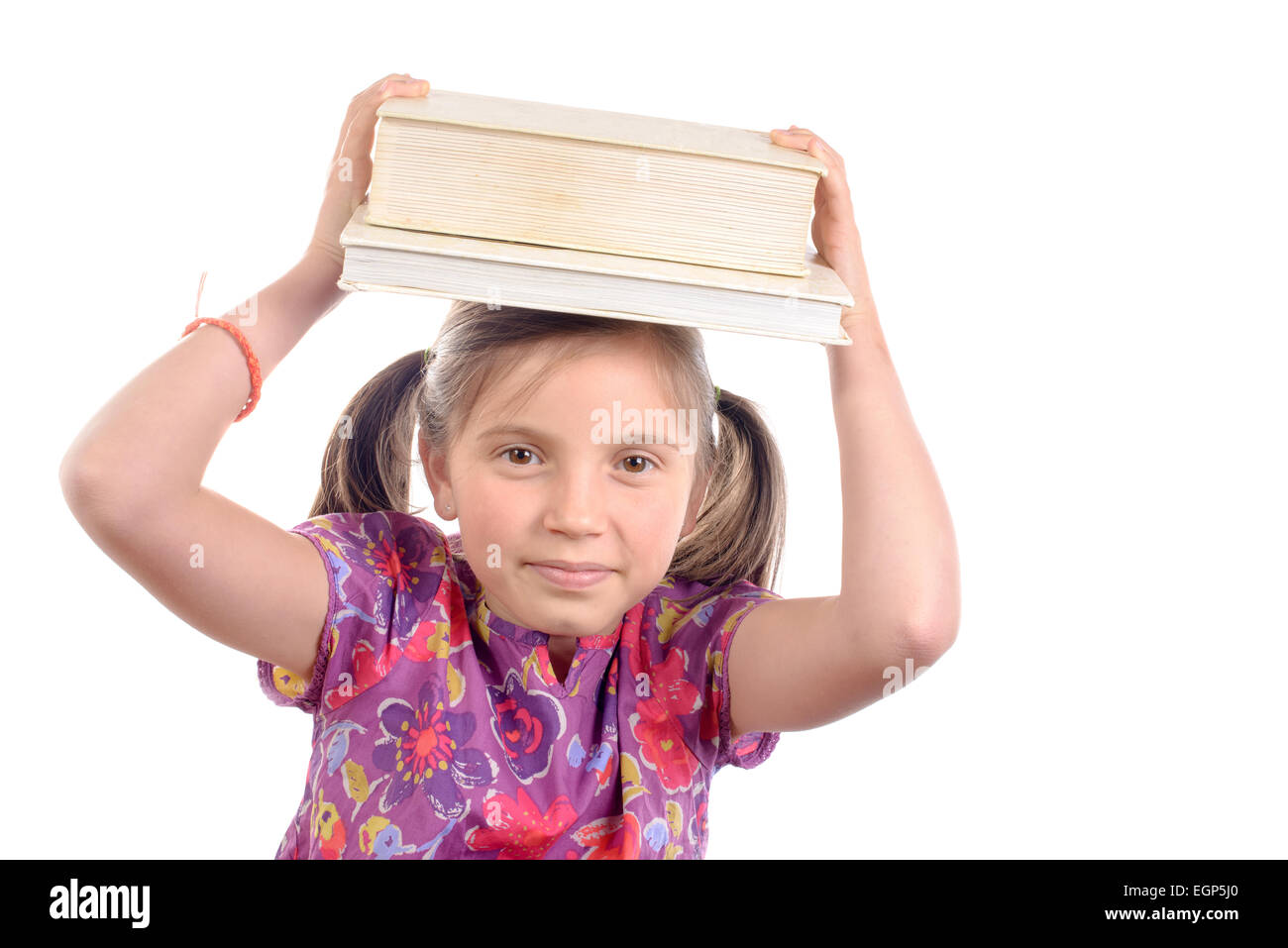 Schoolgirl with pile of books on head on white background Stock Photo ...