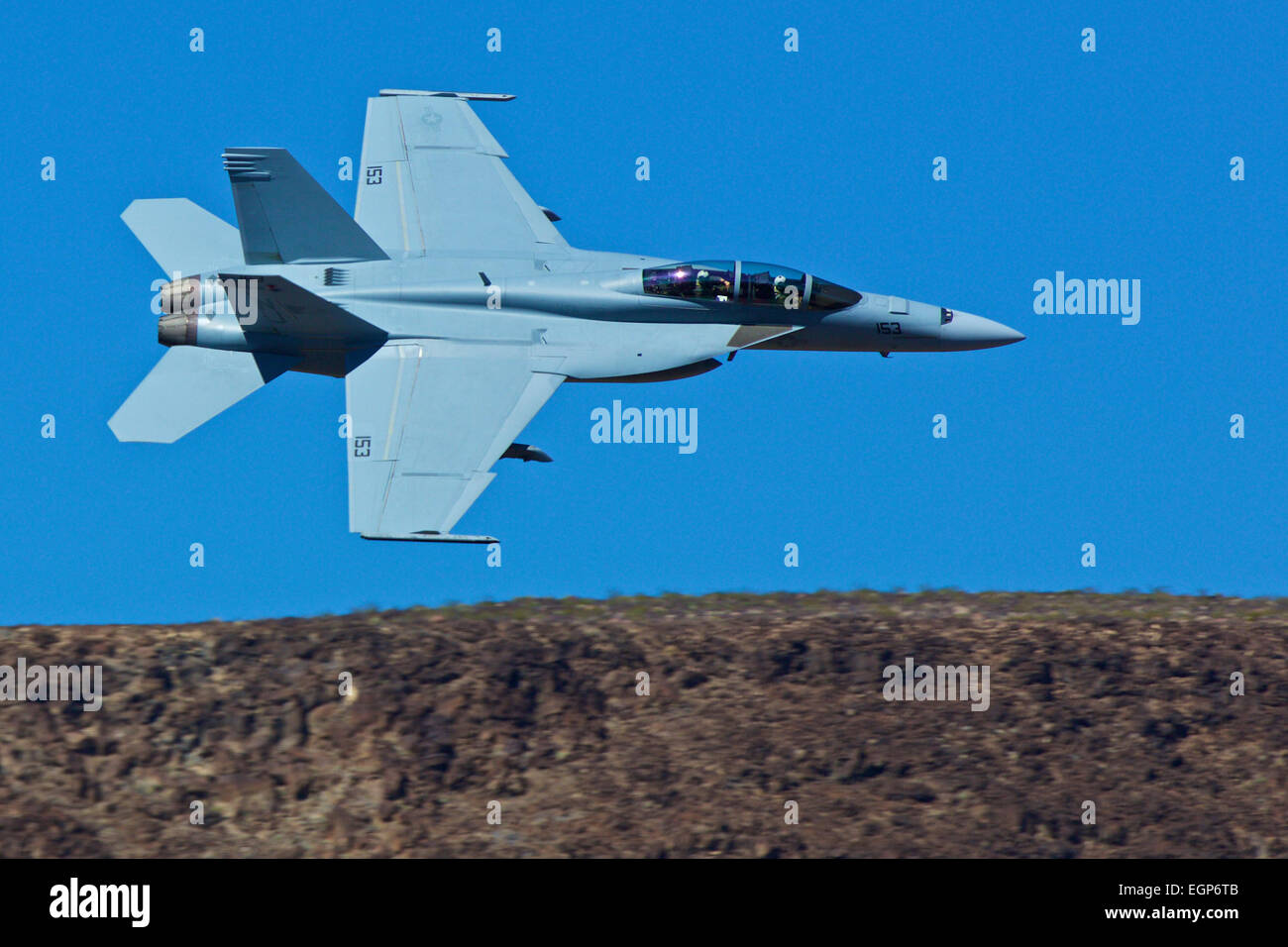 Close Up Topside View Of A US Navy F/A-18F Super Hornet Jet Fighter Flying Along The Rim Of Rainbow Canyon, California. Stock Photo