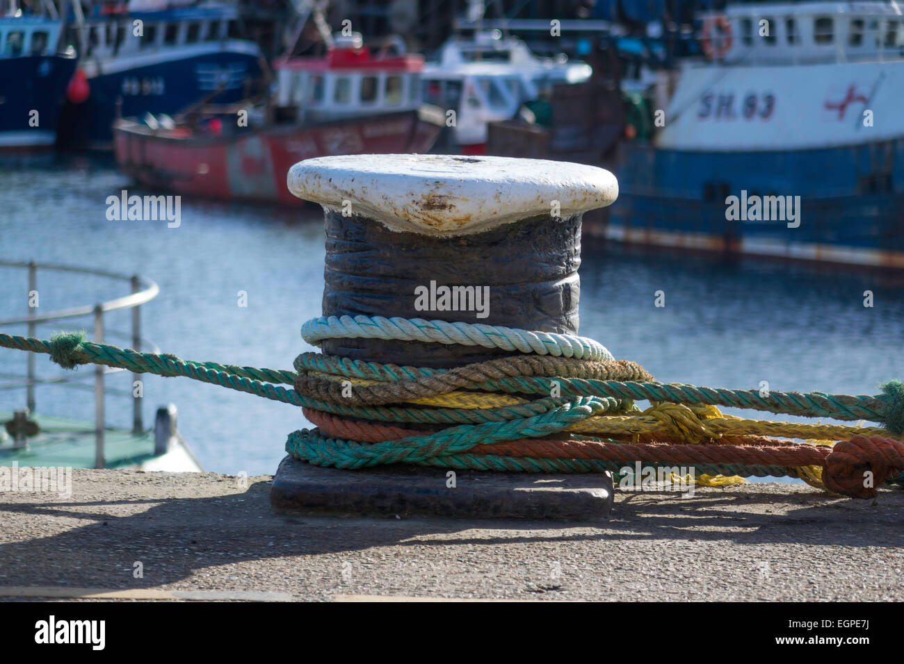 A typical dockside mooring bollard on North Wharf with fishing boat mooring ropes. Stock Photo