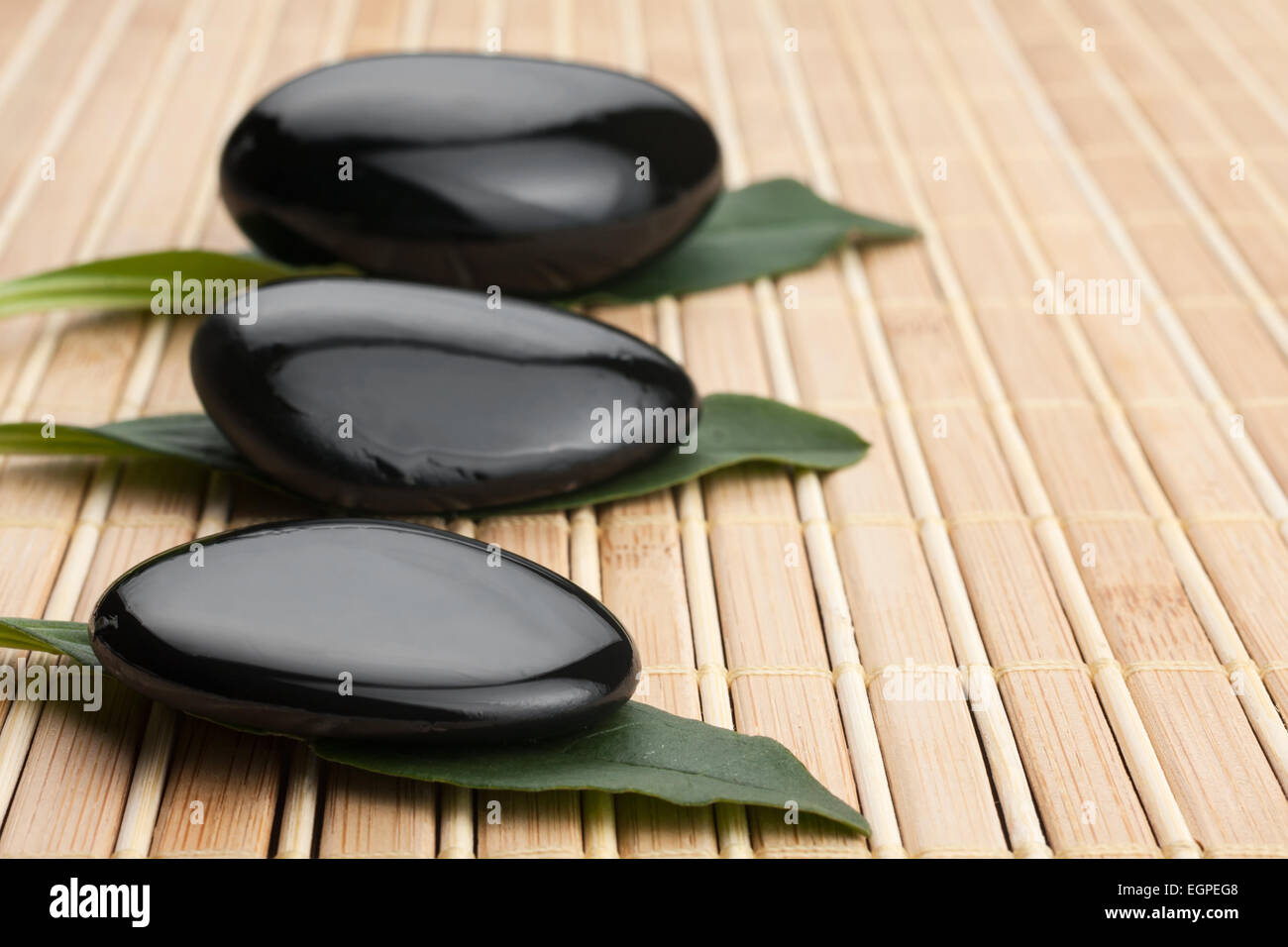 Relaxation Stones at a Spa lying on a bamboo mat Stock Photo