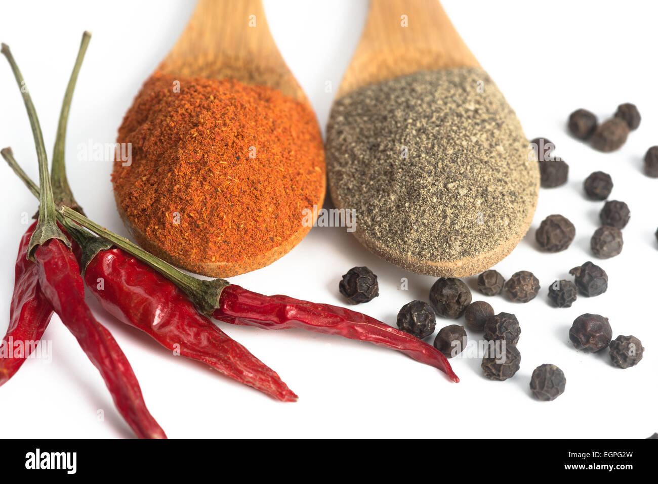 ground red and black pepper in a spoon isolated Stock Photo