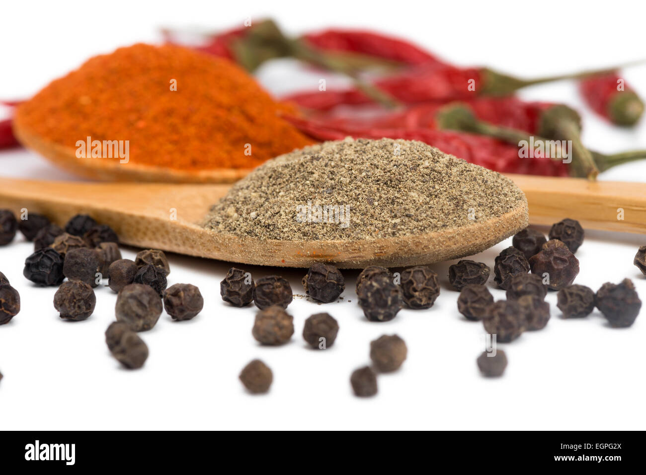 ground red and black pepper in a spoon isolated Stock Photo