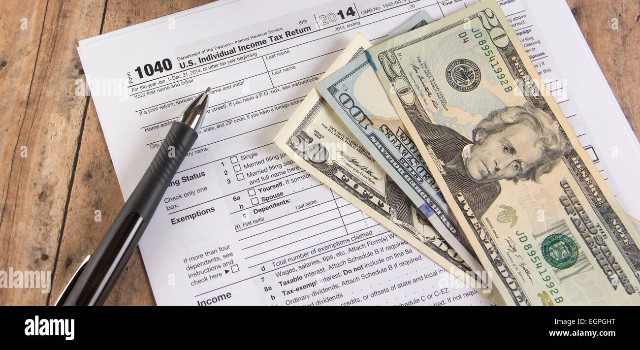 Federal tax deadline - 1040 tax form with  pen anddollar bills Stock Photo