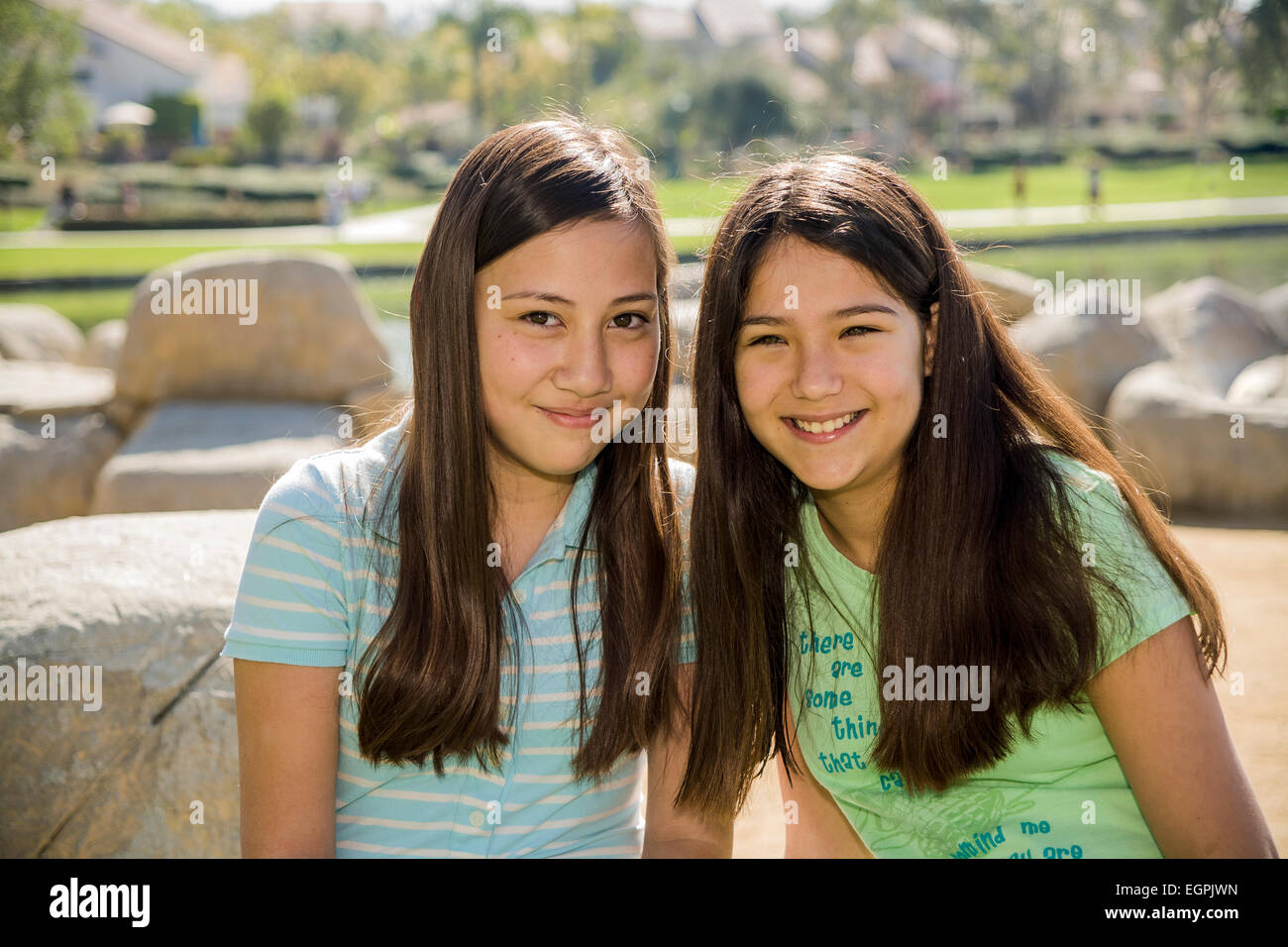 California teens hanging out Vietnamese-Caucasian & Hispanic Mexican Caucasian girls read together in park friendship eye contact MR  © Myrleen Pearson Stock Photo
