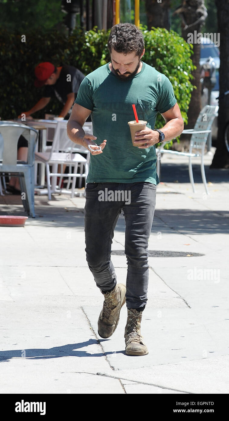 Shia LaBeouf wearing old plain green t-shirt and black skinny jeans with scruffy boots out for an ice coffee Featuring: Shia Where: Angeles, United States When: 26 Aug