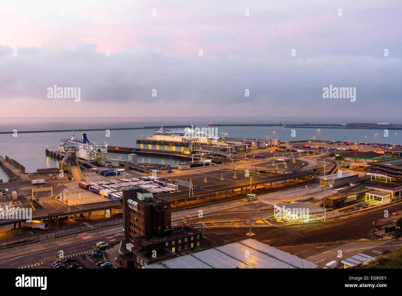 High angle view from the clifftop of the ferry terminal in the dawn at the English Channel port of Dover. 2 car ferries berthed at embarkation points. Stock Photo