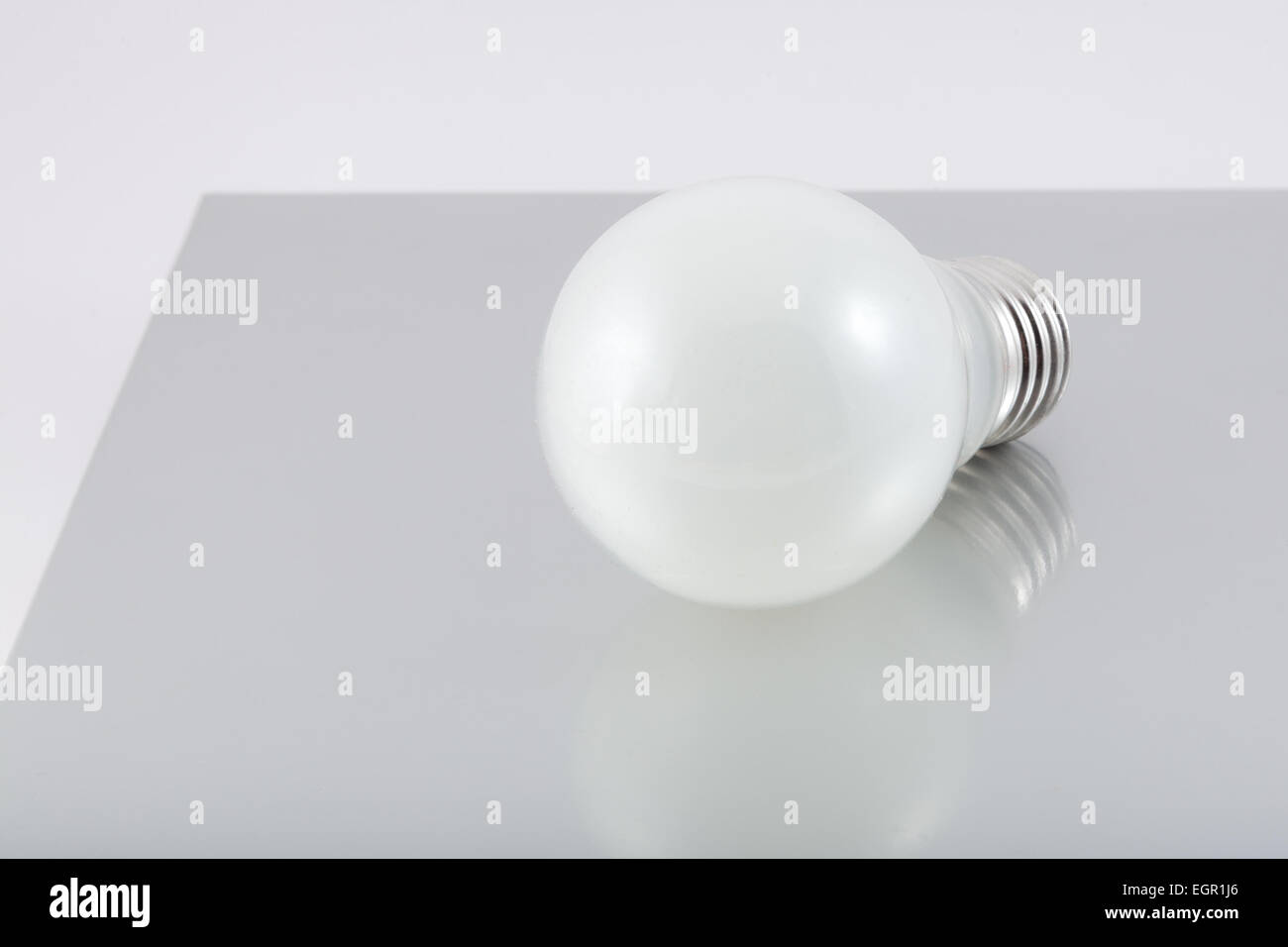 the glow lamp lies on a gray flat surface Stock Photo