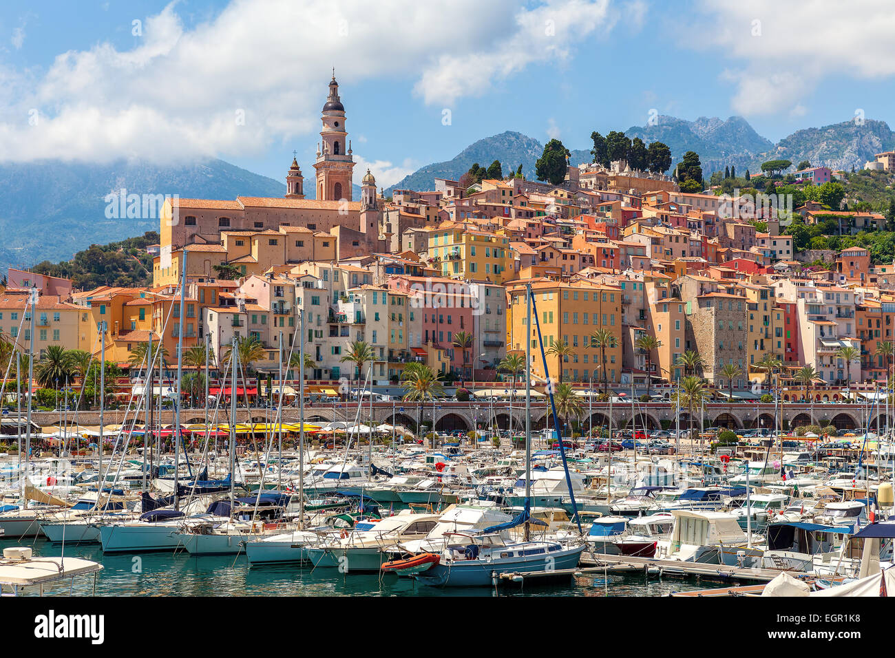 Old colorful houses overlooking small marina with yachts and boats in Menton - town on French Riviera. Stock Photo