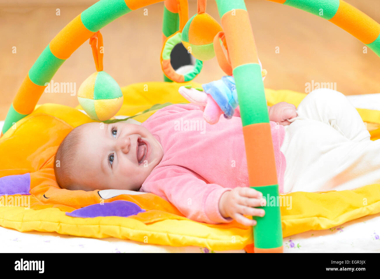 Innocent baby smiling and playing with toys Stock Photo