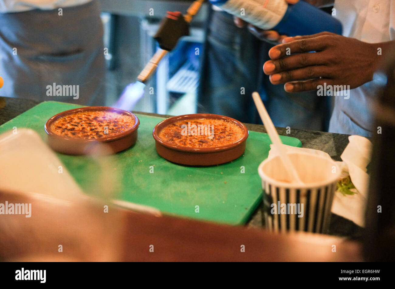Afrocaribbean chef making crem brulee with a blow torch Stock Photo