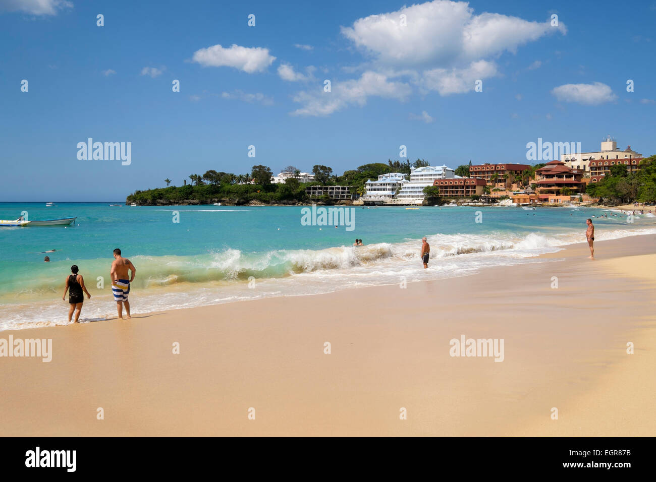 Tourists on a sandy beach on Atlantic ocean in holiday resort of Sosua, Dominican Republic, Caribbean Islands Stock Photo