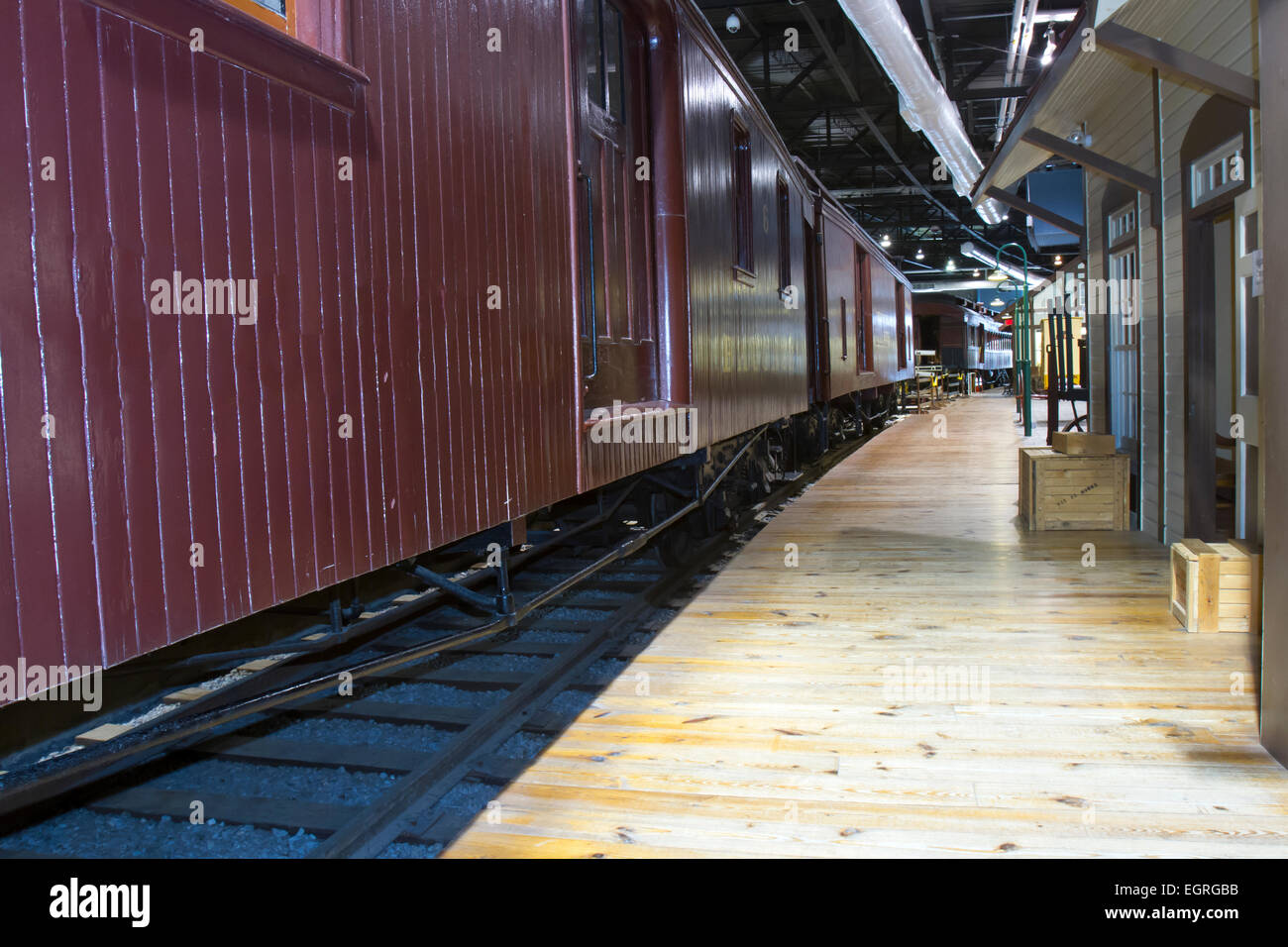 Antique railroad boxcar alongside platform at train station Stock Photo