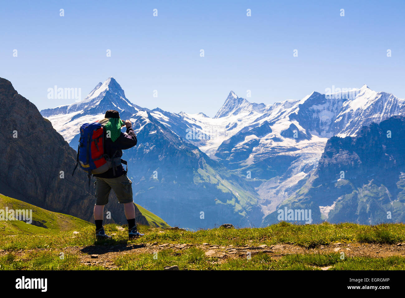 Walker photographing the rugged mountains of the Bernese Alps,  high above Grindelwald, Switzerland Stock Photo