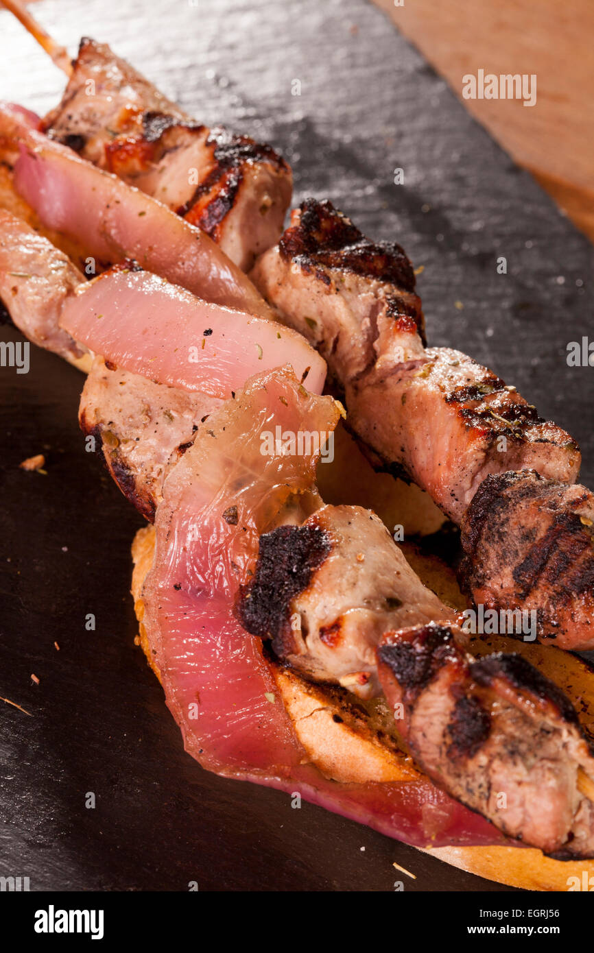 Souvlaki pork beef onions tomato grilled meat plate cooked tasty bread