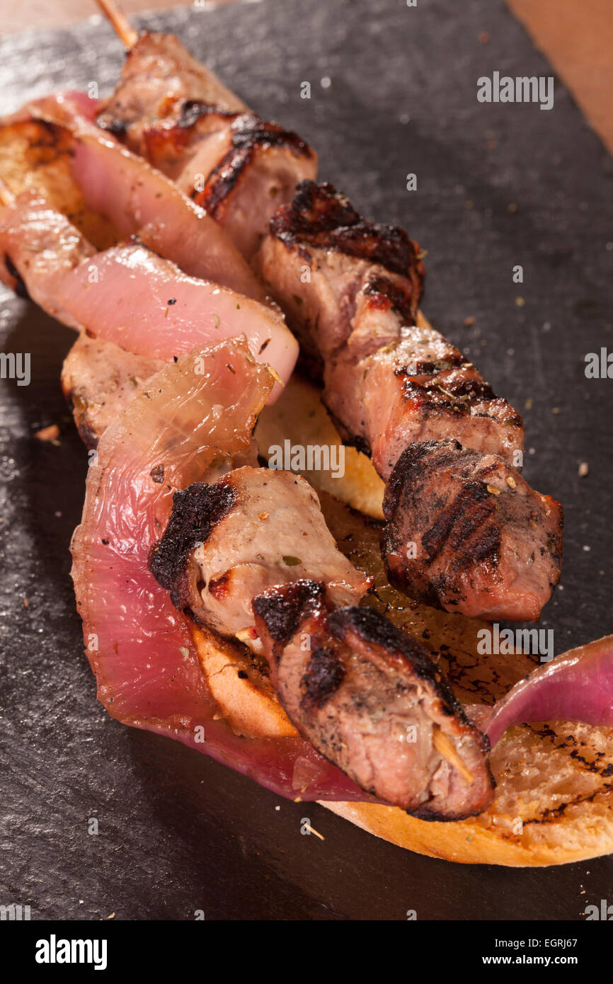 Souvlaki pork beef onions tomato grilled meat plate cooked tasty bread