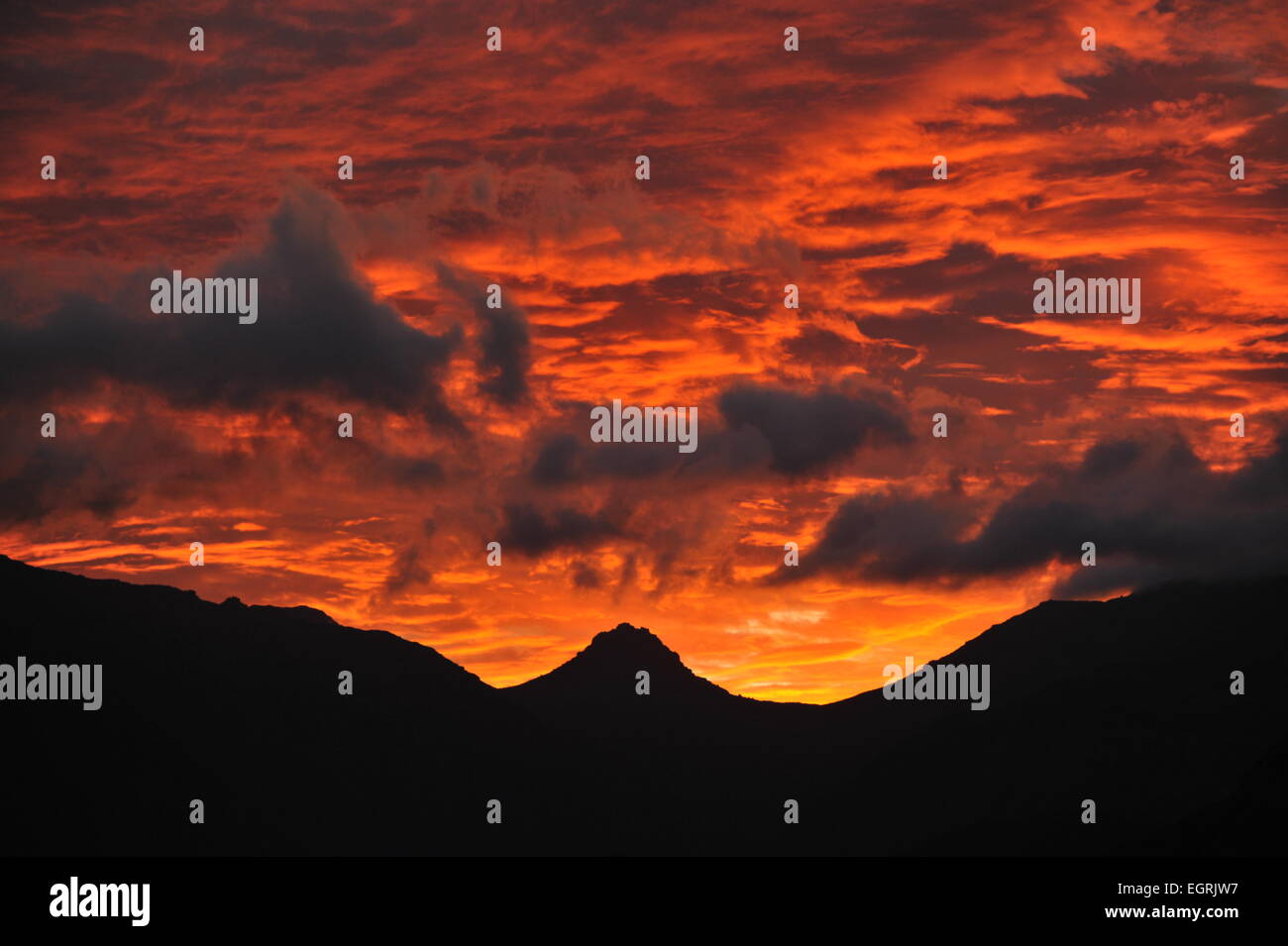 Western Cape, South Africa. 1st March 2015. The sky burns orange as the sunsets over the Hottentot Holland Mountains between Stellenbosch and Franschoek, Western Cape, South Africa Credit:  STUART WALKER/Alamy Live News Stock Photo