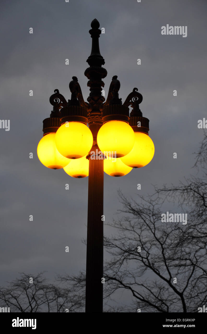 a vintage light post with yellow light at dusk Stock Photo