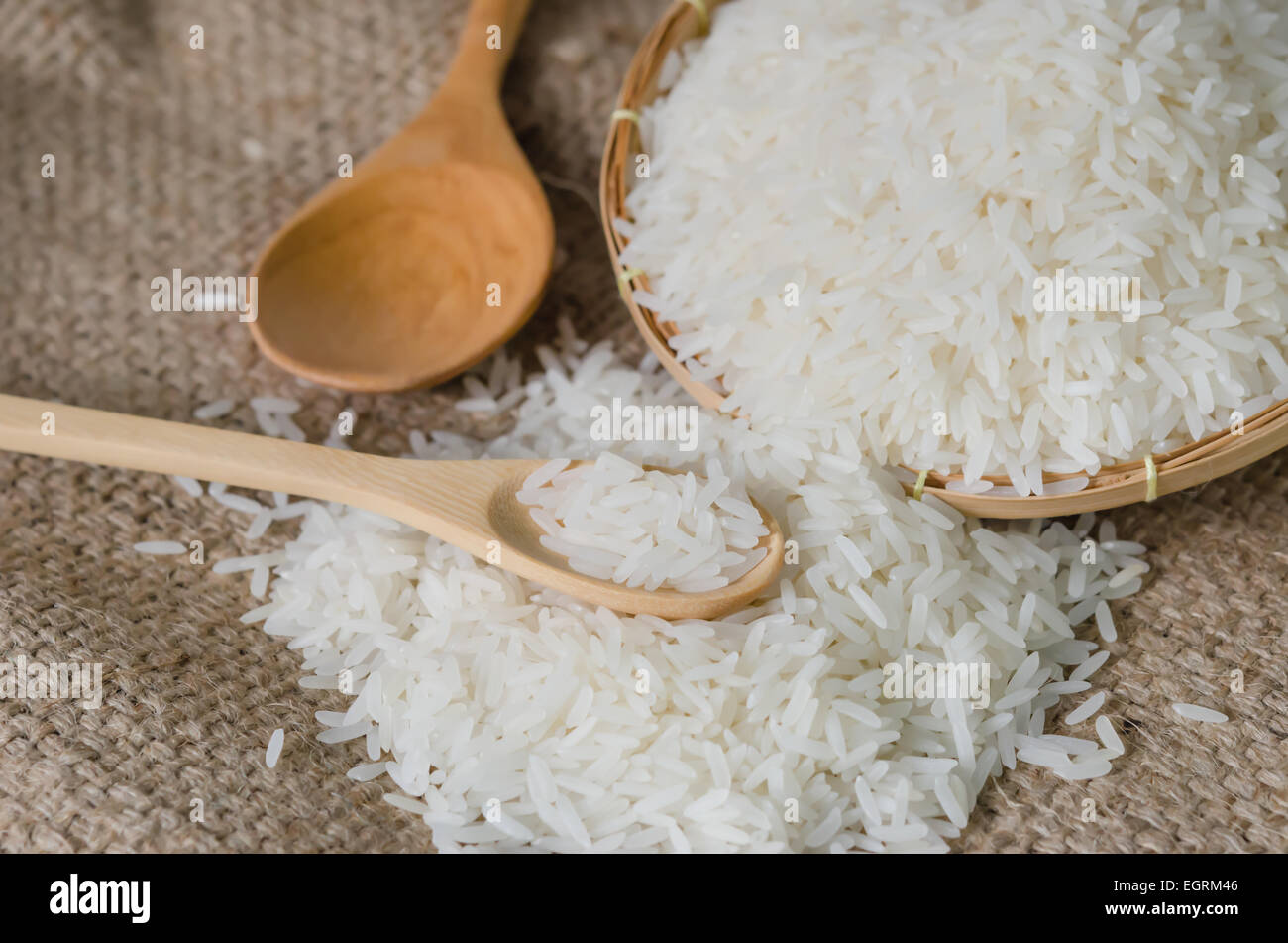 white rice grains with wooden spoon on sackcloth Stock Photo - Alamy