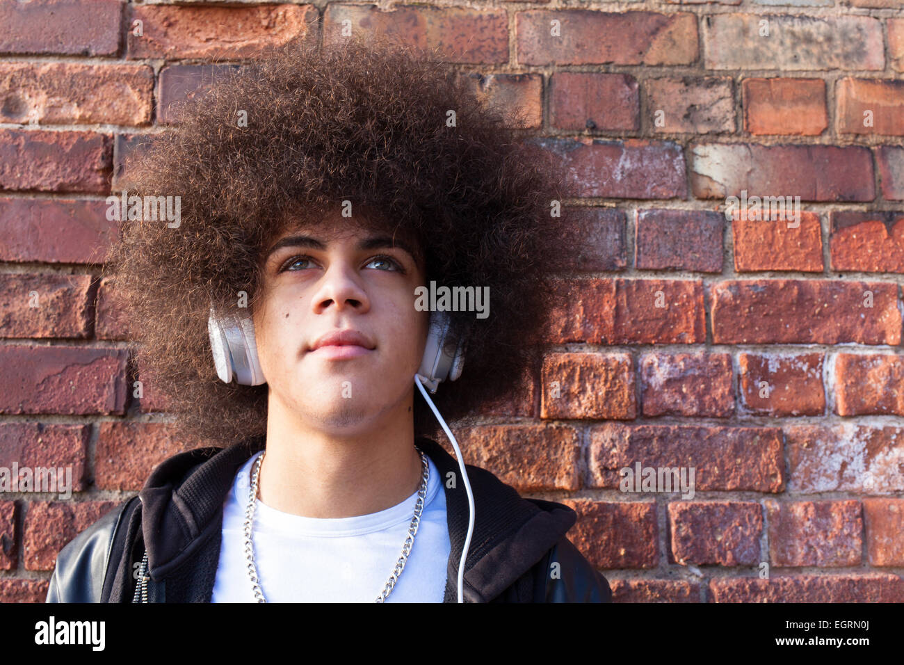A teenager listening to music wearing Dr Dre Beats headphones. Stock Photo