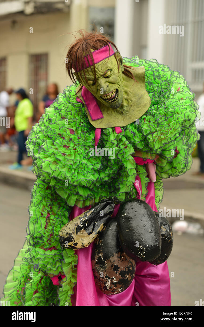 Bright green and purple masked Vejigante playing in the streets of Ponce, Puerto Rico during the carnival 2015 Stock Photo