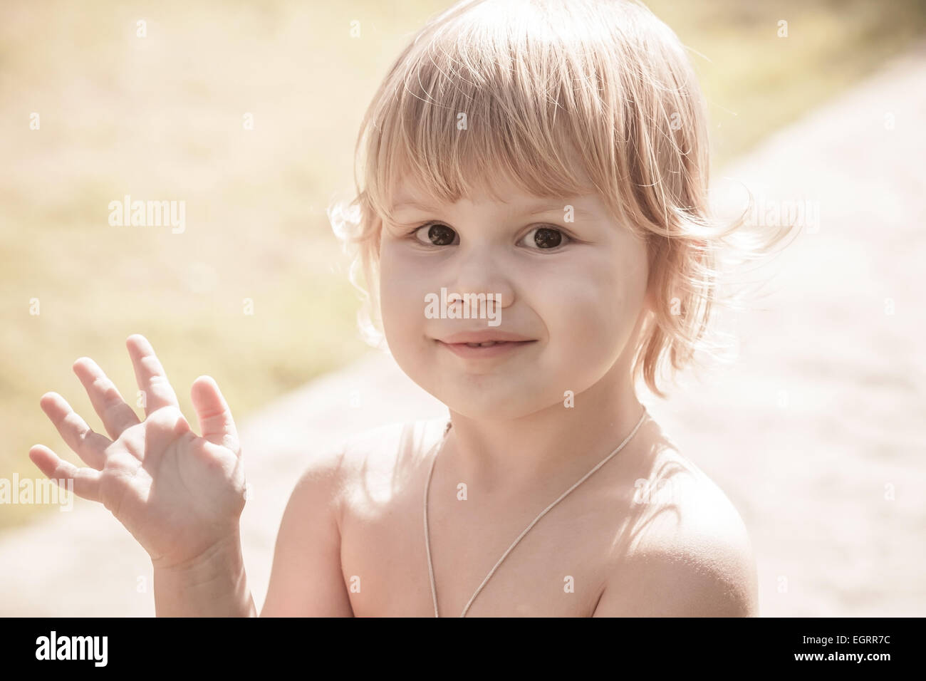 Outdoor closeup portrait of cute smiling Caucasian blond baby girl ...