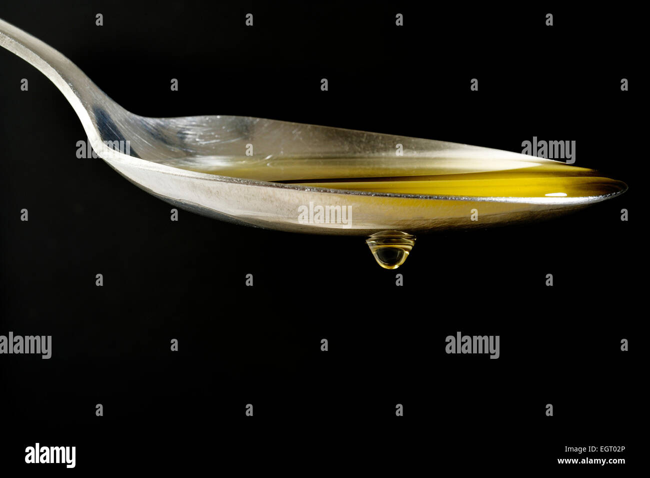olive oil drops dripping from spoon Stock Photo Alamy
