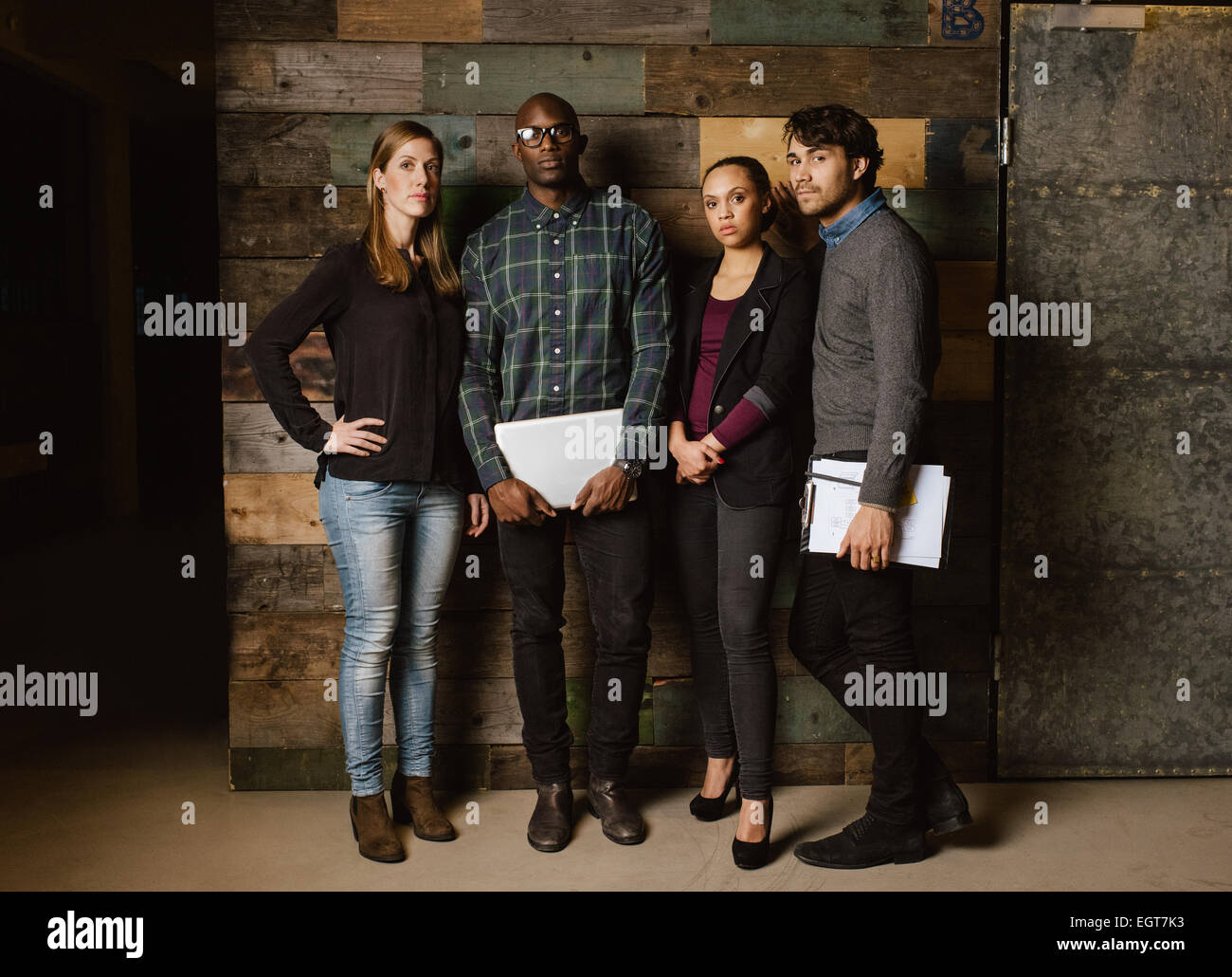 Portrait of young professionals standing together in office. Diverse group of young executives at work. Stock Photo